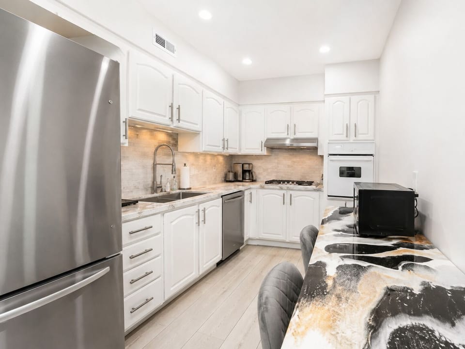 Fully equipped kitchen with stainless steel appliances and breakfast bar