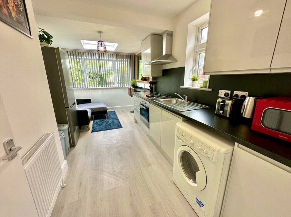 Kitchen angle showing oven, washer, and fridge