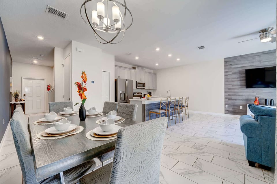 Open-concept dining and kitchen area with modern furnishings and ample seating.