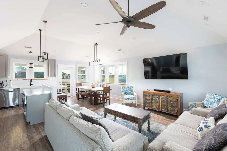 Top Level: Open-concept living, dining, and kitchen area with Smart TV, sound system, and comfortable seating.
