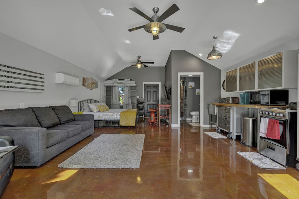 Spacious open-concept living with modern industrial kitchen, cozy lounge, and comfy sleeping area—perfect for a stylish Hill Country stay in Fredericksburg. Enjoy rustic charm with all the essentials and sleek finishes.
