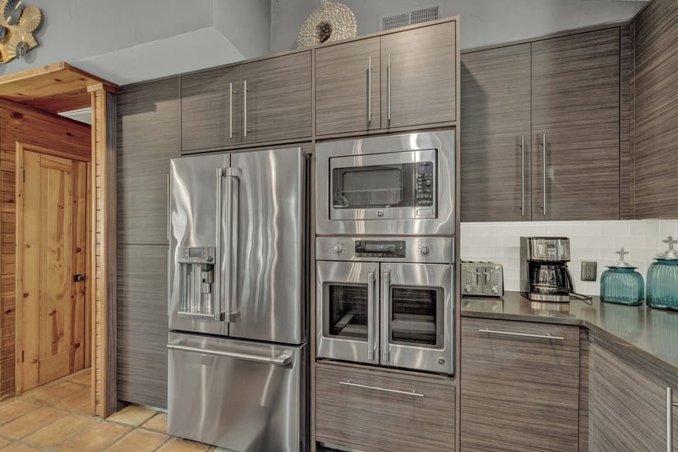 Kitchen with modern stainless steel appliances, including a sleek fridge, oven, and microwave.