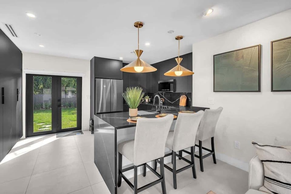 Fully equipped kitchen with direct access to the backyard, offering plenty of natural light and a pleasant atmosphere for cooking or enjoying meals in the dining area.