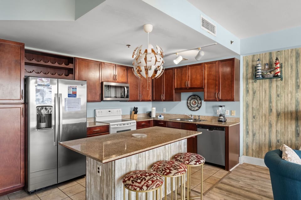 Modern kitchen with stainless steel appliances and a central island with seating.
