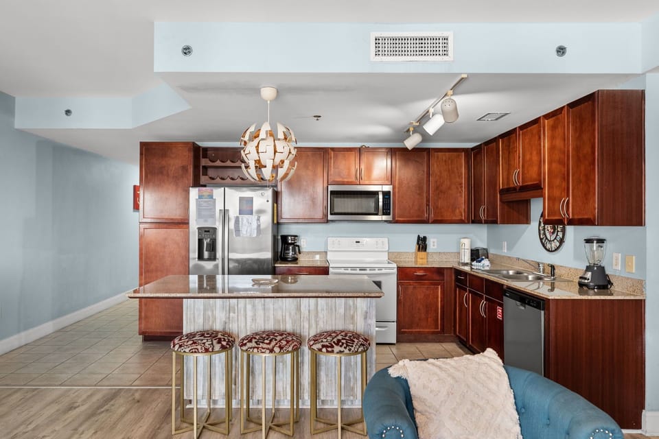 Modern kitchen with wooden cabinetry and a central island featuring patterned stools.
