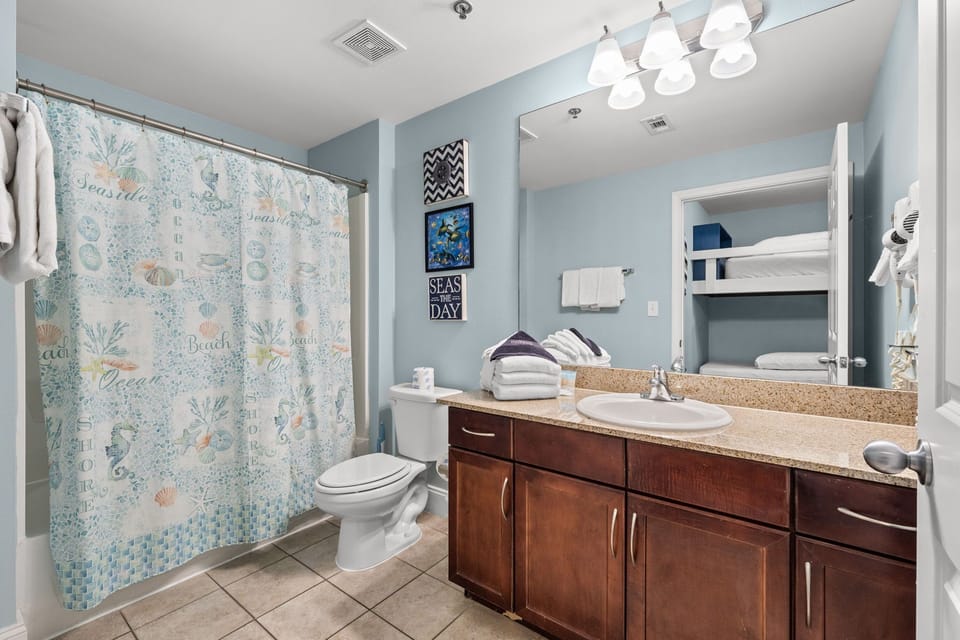 Bathroom with a shower-tub combination and dark wood cabinetry.