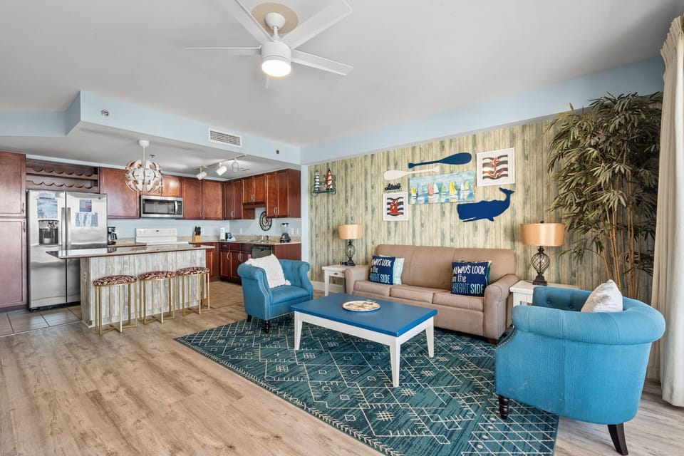 Open-concept living area with coastal decor and a fully equipped kitchen.