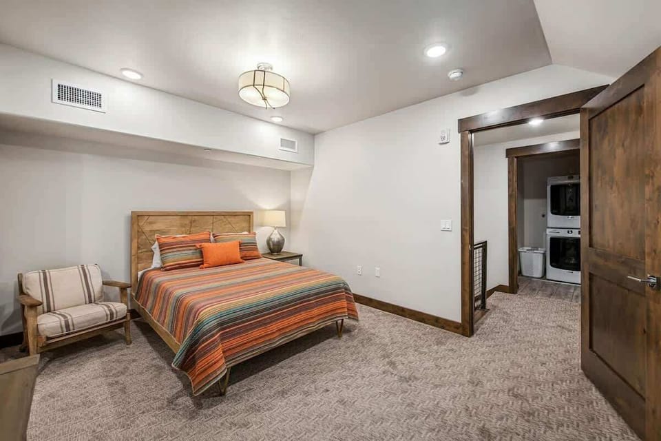Upstairs loft bedroom entrance at the top of the stairs, with laundry room access across the hall