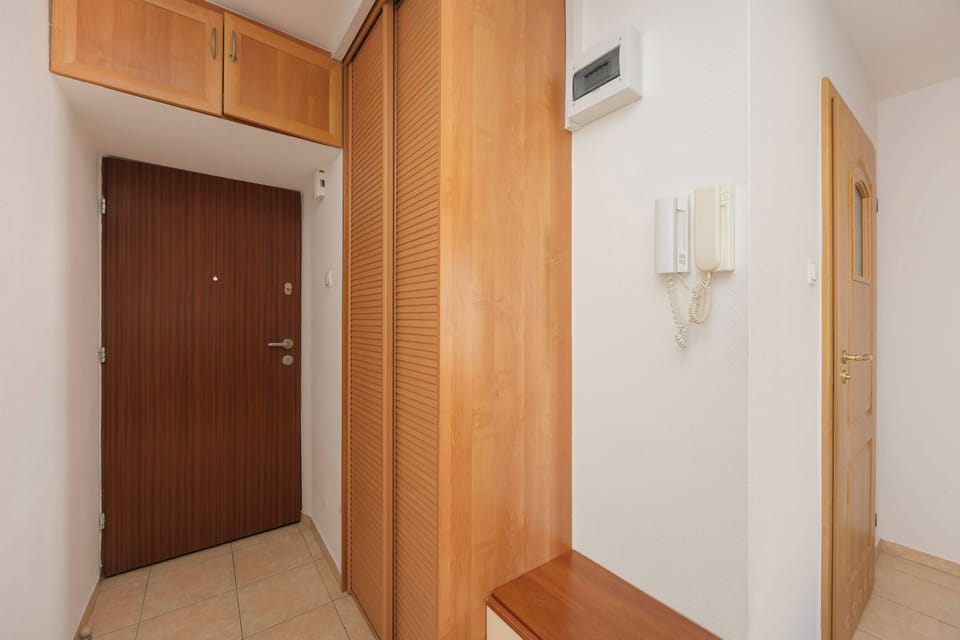 A spacious hallway with wooden finishes welcomes guests with the warmth and elegance of natural materials.