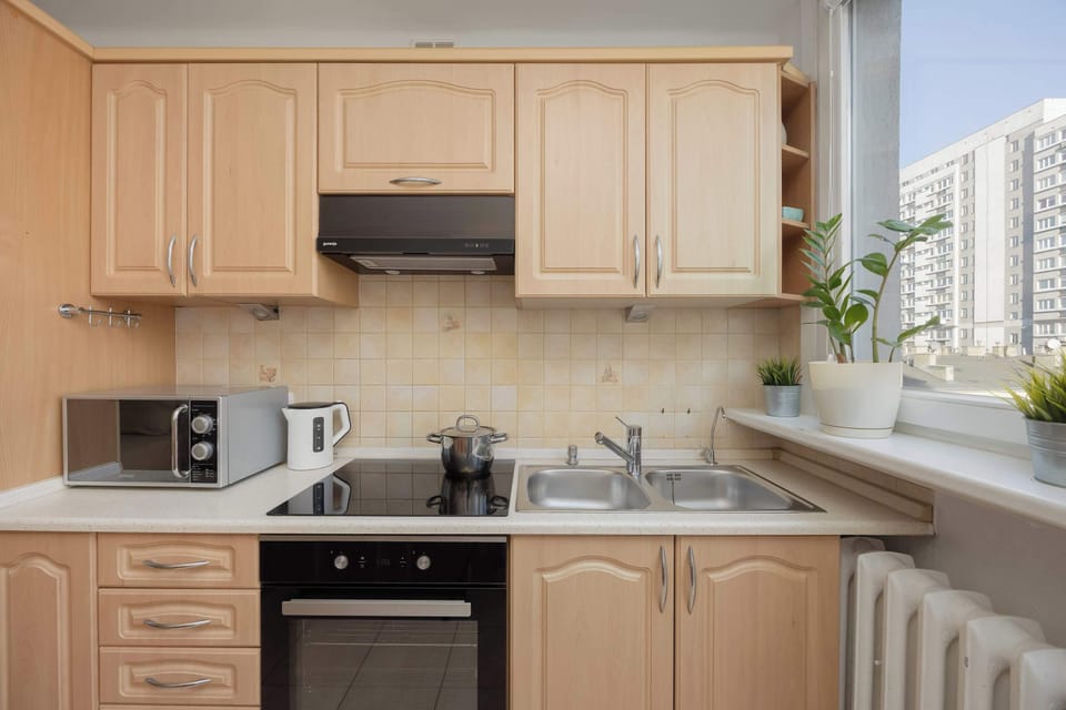 The bright kitchen with a large window and full equipment invites you to cook while enjoying the city view.