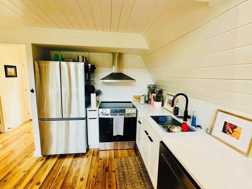 Kitchen includes large fridge, electric stove, dishwasher