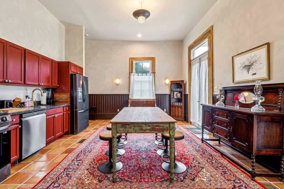 Open kitchen with bold cabinetry and an antique-style farmhouse table.