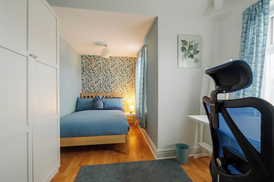 Set up for both rest and productivity, the third bedroom includes a comfortable bed, bedside table, wardrobe, and a dedicated work desk with an ergonomic chair—perfect for remote work or study during your stay.
