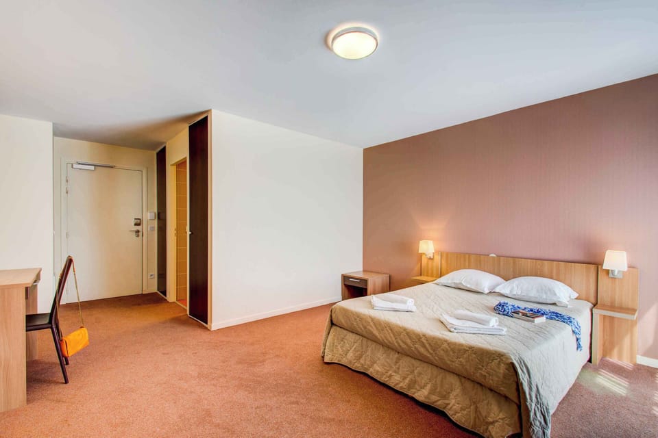 Spacious and well-lit double room featuring a separable double bed, cozy decor, and warm tones for a relaxing stay.