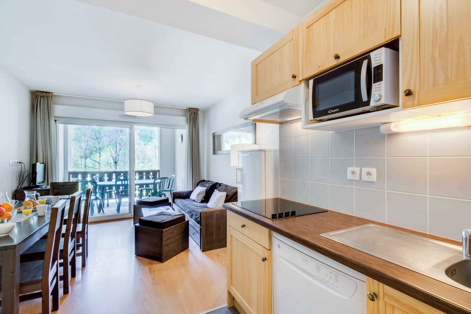 Bright and fully equipped kitchen with everything you need to prepare family meals — including a microwave, dishwasher, and dining area opening onto the living space. Perfect for cozy dinners after a day exploring the mountains.
