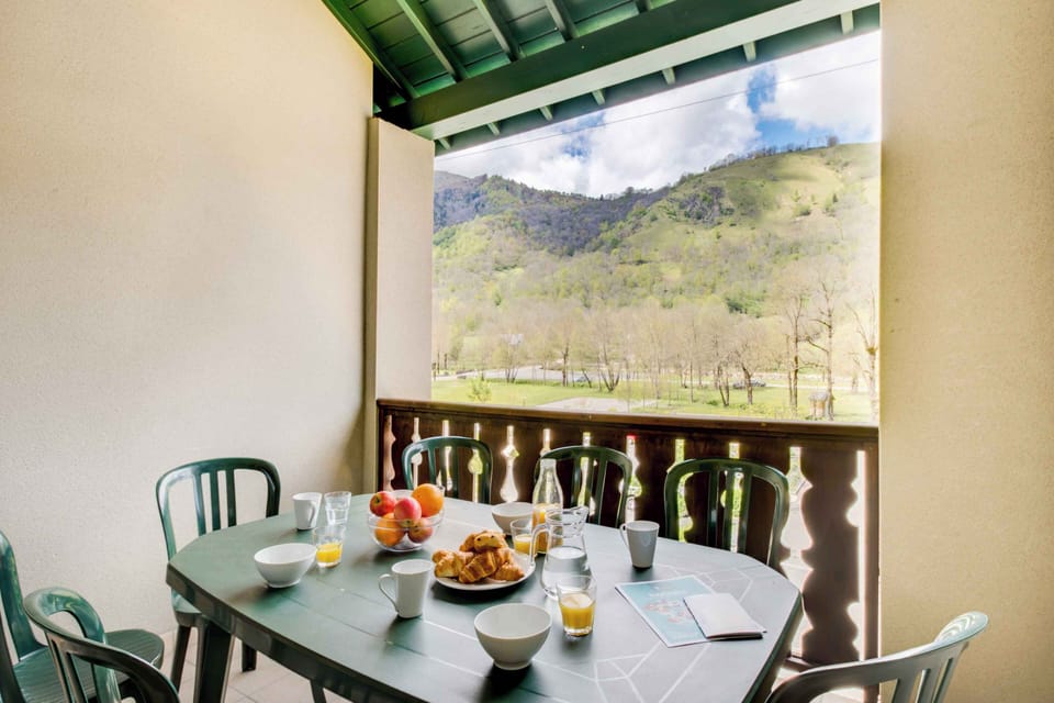 Private balcony with outdoor dining set and breathtaking views of the surrounding Pyrenees. Enjoy breakfast in the morning sun or unwind with a glass of wine while taking in the mountain air.
