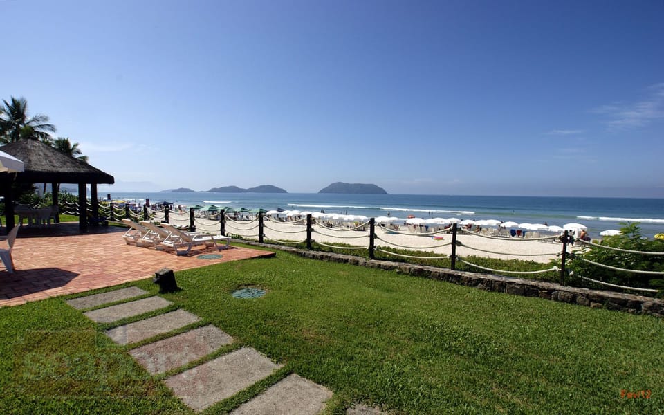 área do condomínio frente ao mar, com banheiros, chuveirão, quiosque, cadeiras