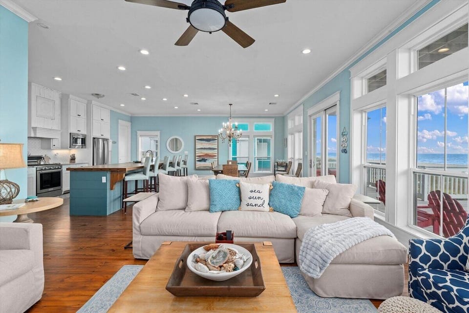 Bright coastal living space with sectional sofa, ocean views, and open layout for group gatherings