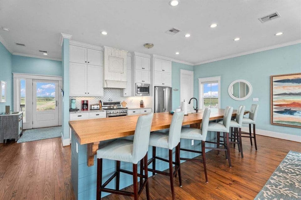 Fully equipped kitchen with large island, bar stools, and modern appliances for vacation cooking