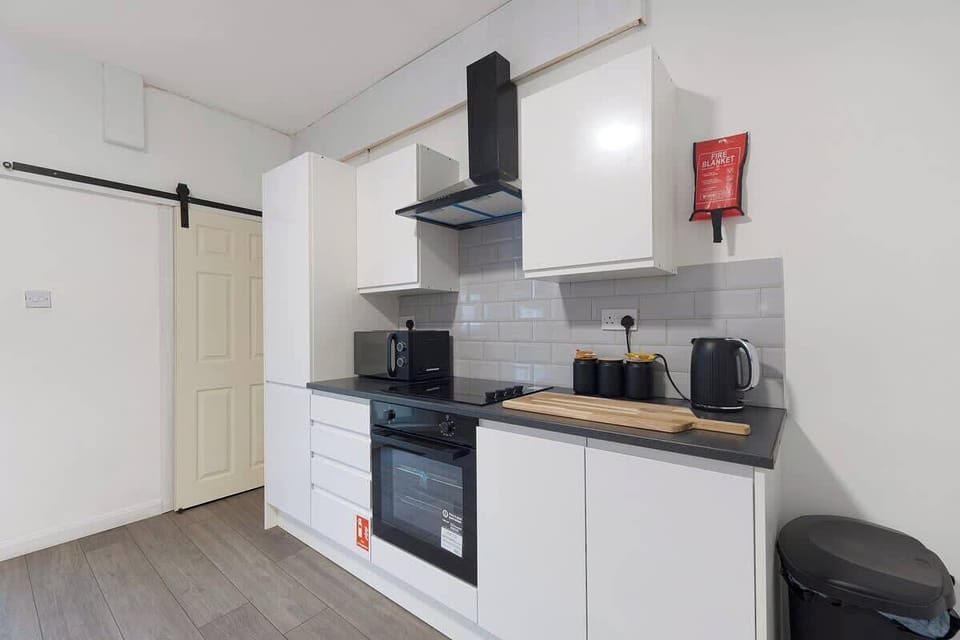 Kitchen equipped with all essentials, including an oven, fridge, and full cookware set.