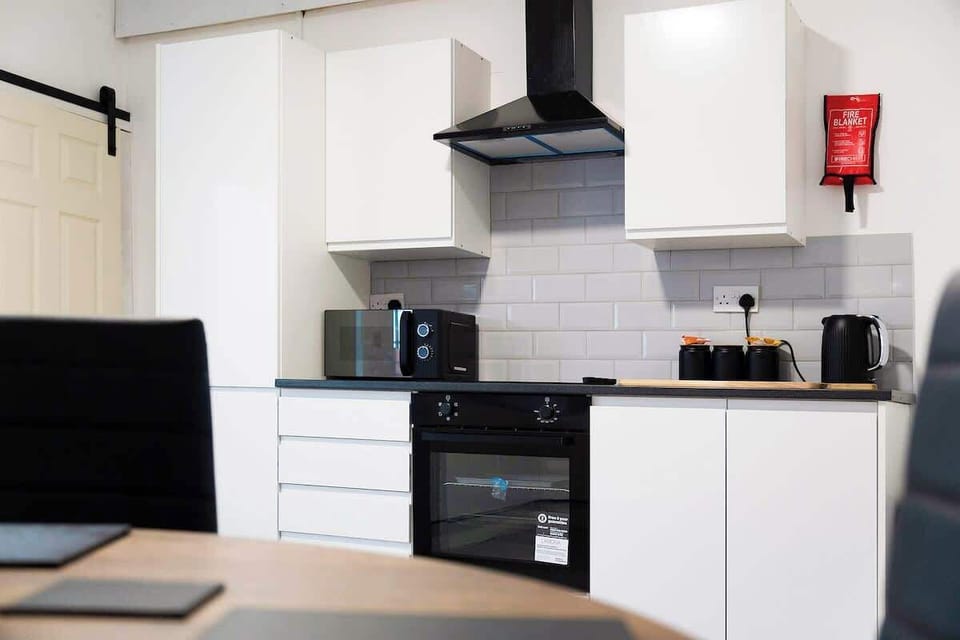 Kitchen equipped with all essentials, including an oven, fridge, and full cookware set.