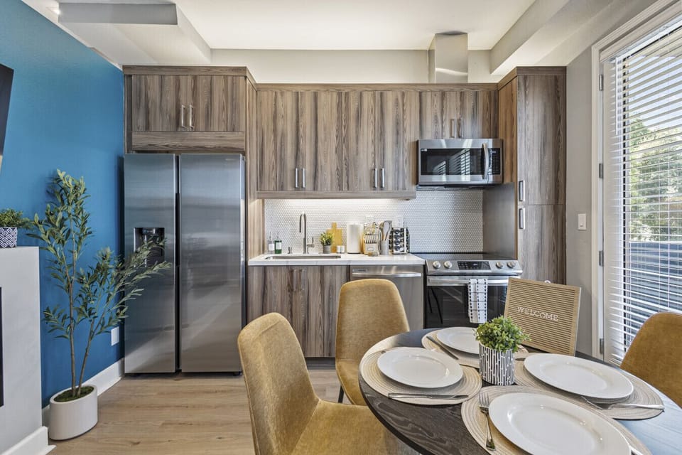 Modern kitchen and dining area with stainless steel appliances.