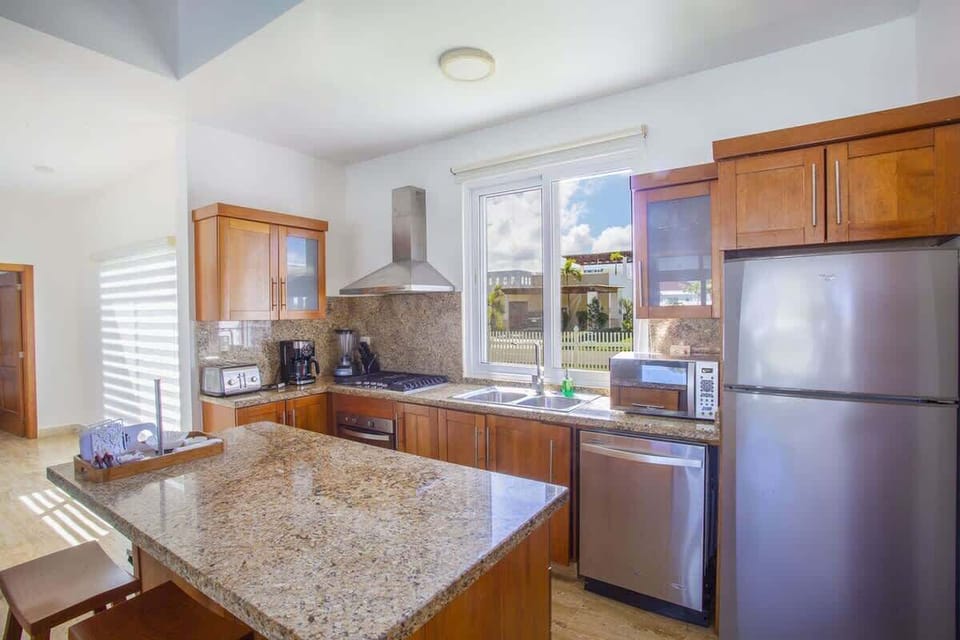 odern kitchen featuring granite countertops, a large island, and complete cookware.
