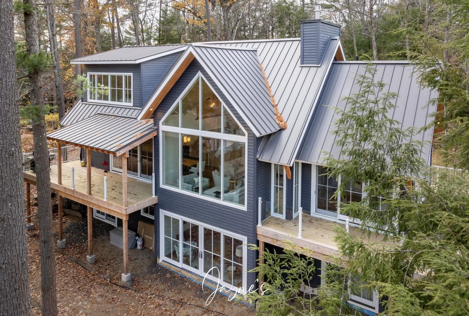 Modern forest retreat with expansive windows and cozy decks
