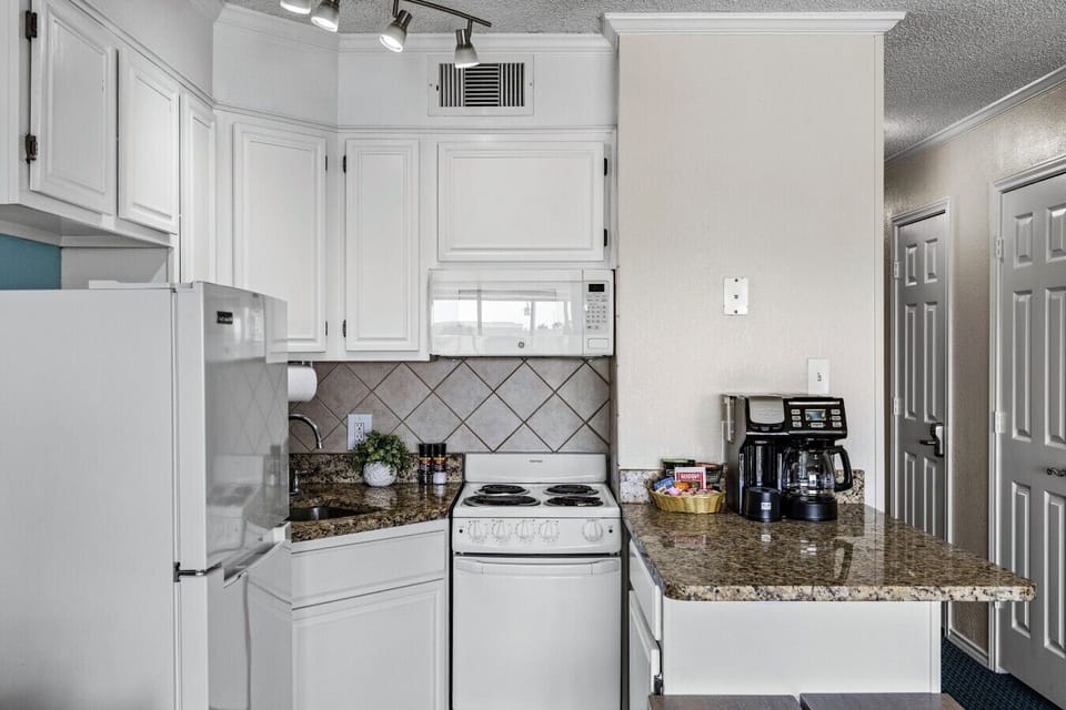 Fully equipped kitchen with full-size refrigerator, stove, and coffee setup—everything you need for easy meals during your stay.