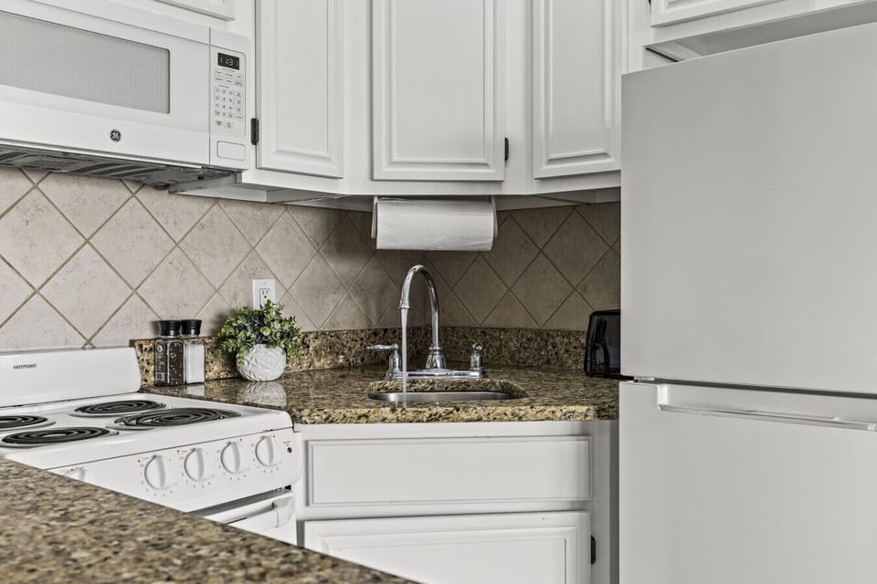Clean and functional kitchen space with granite counters and full-size appliances