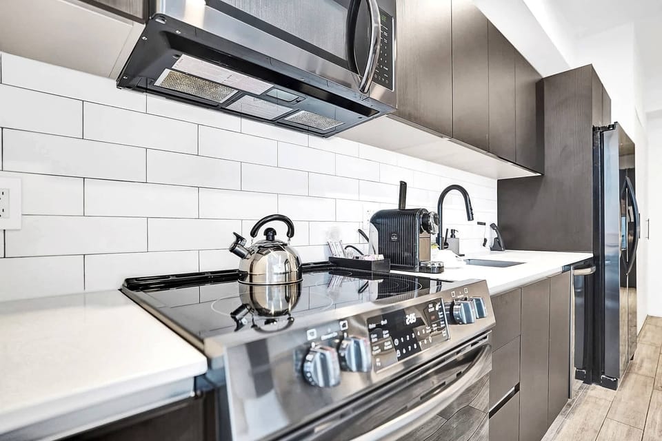 Kitchen stovetop with subway tile and overhead microwave