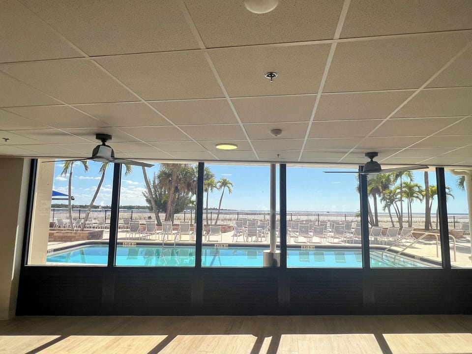 2025 photo -standing inside common area room looking through windows to pool area. HOA office for registration location in this area.