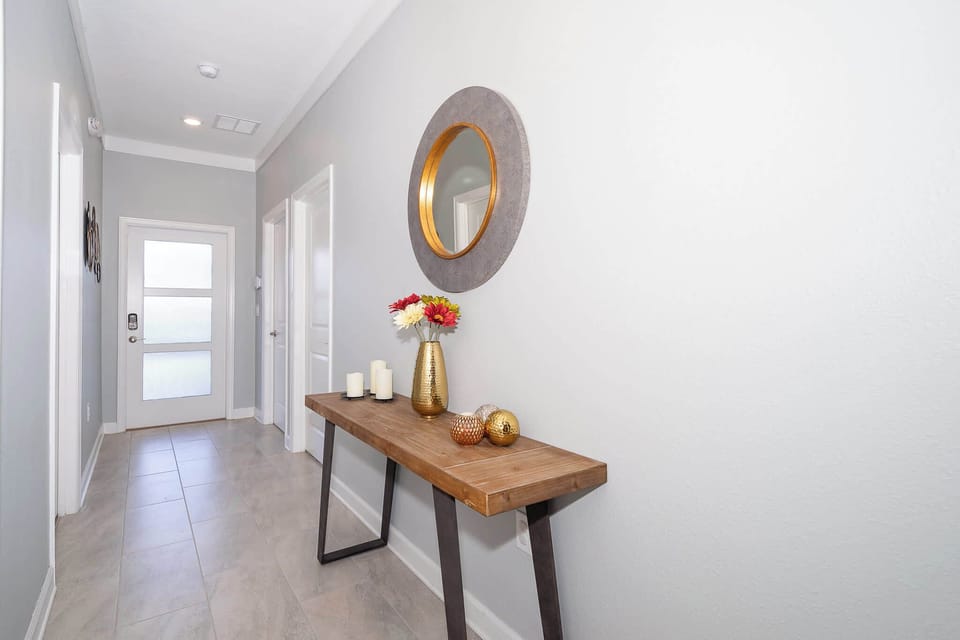 Modern hallway with a wooden console table and decorative mirror for a welcoming entry.