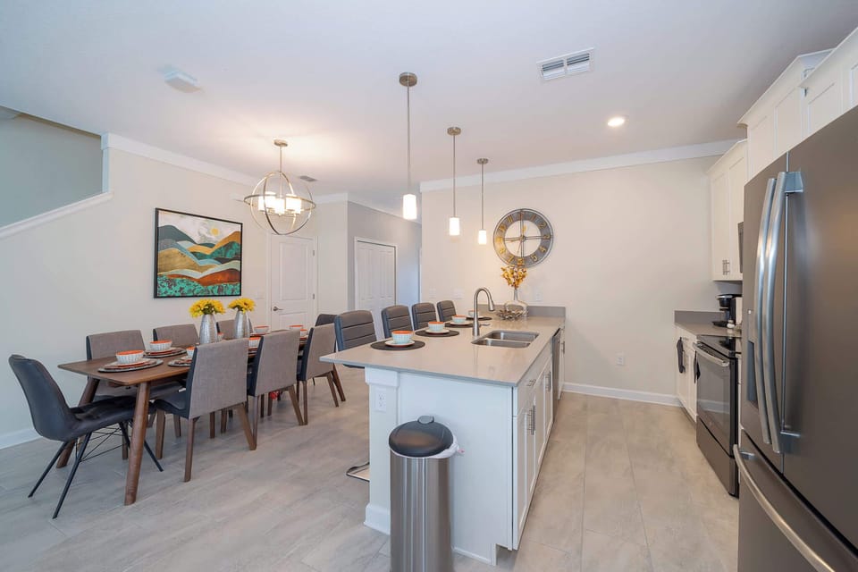 Modern kitchen and dining area with a large island and seating for eight.