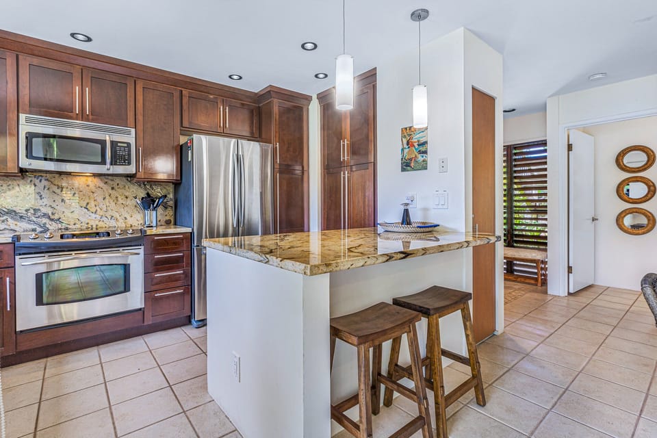 Kitchen with sleek countertops, wooden cabinetry, and open shelving for a stylish and functional space.
