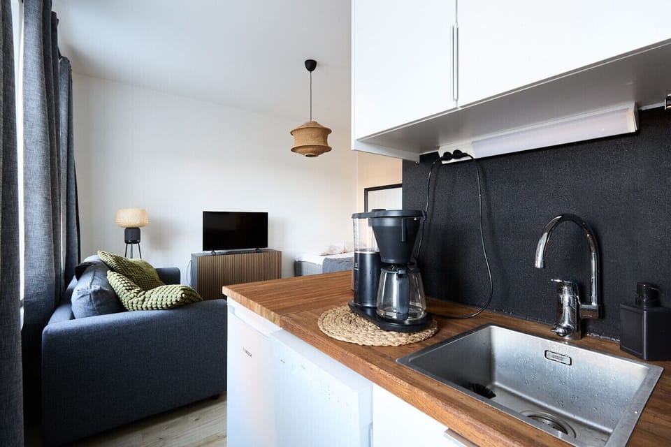 Prepare your favorite meals in the fully equipped modern kitchen featuring all necessary appliances and cookware. Start your mornings right with a fresh cup of coffee at the stylish breakfast bar.