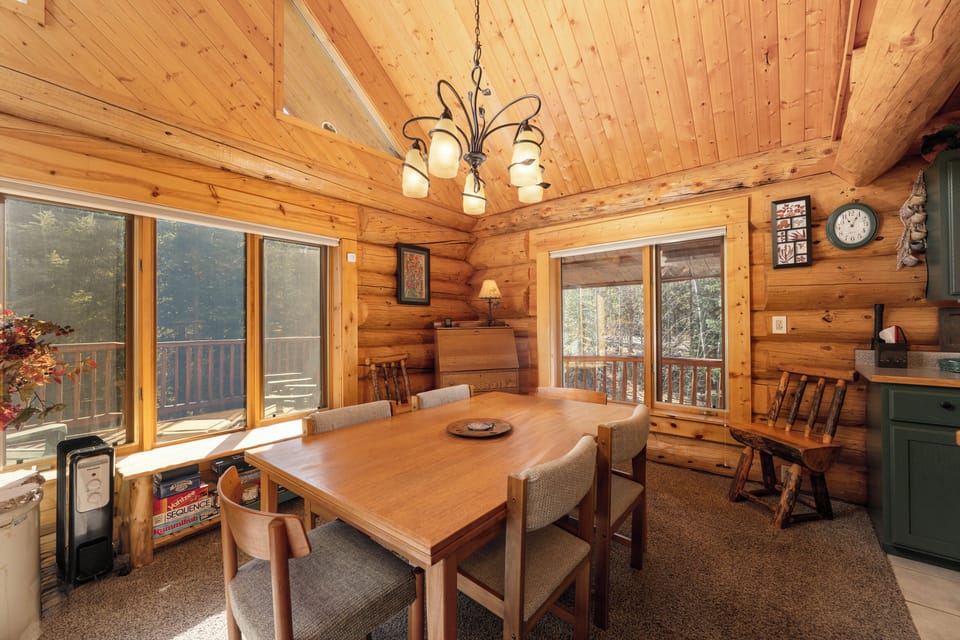Gather around this warm dining space where rustic wood meets modern comfort, perfect for family meals with forest views.