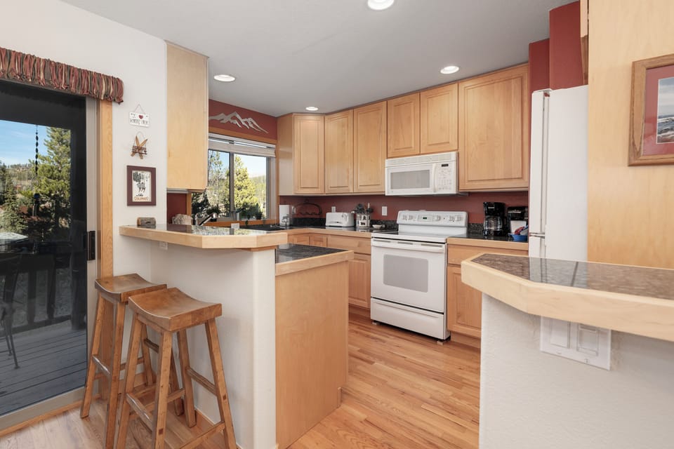 Your spacious kitchen features warm wood cabinets, granite counters, and everything you need to create delicious meals during your mountain getaway.