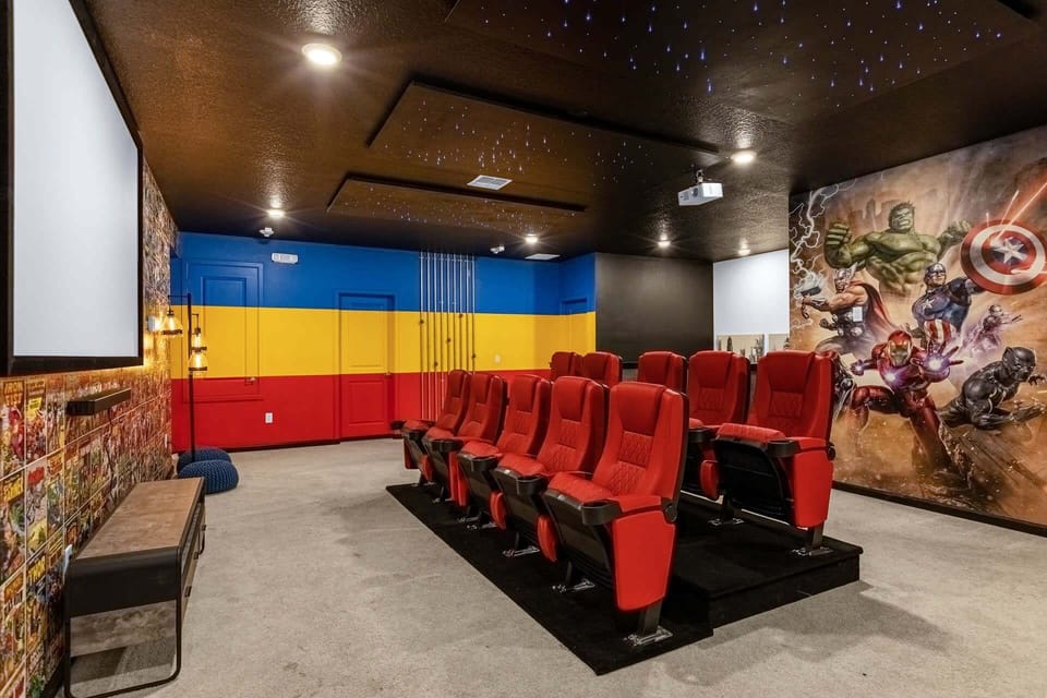 Comic book wallpaper and a superhero mural decorate the walls in this in-home movie theatre.