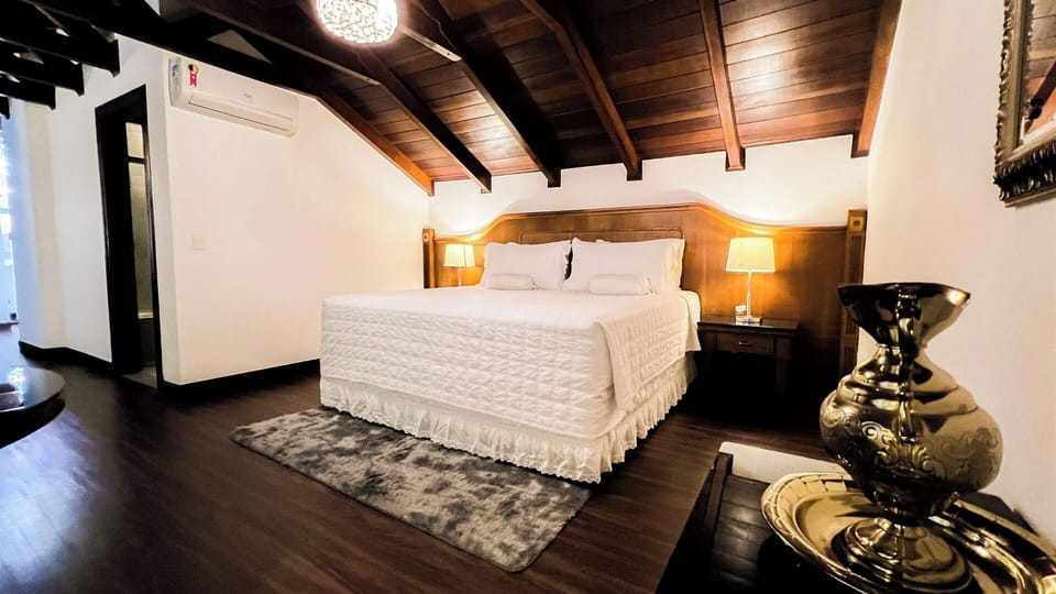 Unwind beneath rustic beams in a plush, serene king bed.