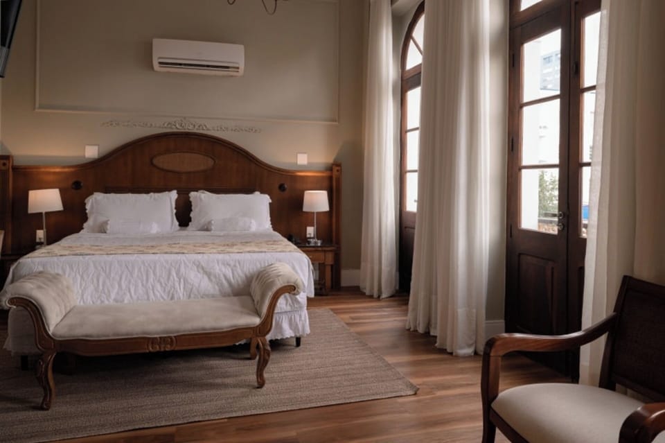 Wake to soft daylight beside elegant arched windows and linens.