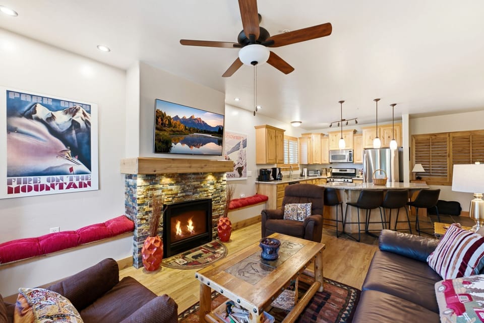 Open living area with fireplace and kitchen, perfect for relaxing together.