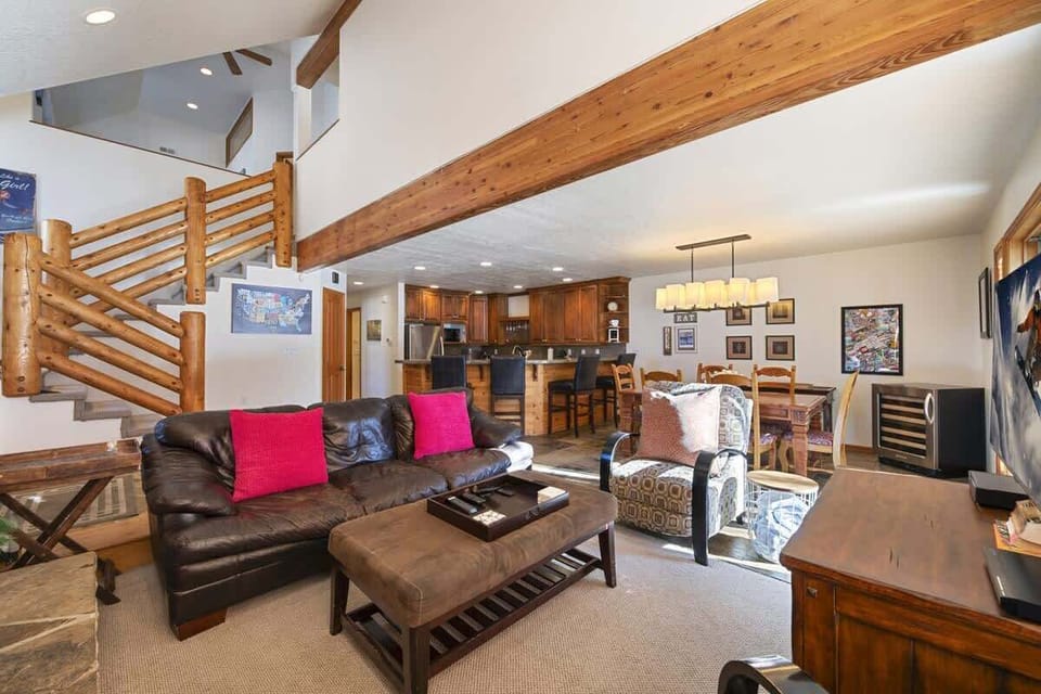 Spacious open-concept living area with cozy seating, rustic wood accents, and a fully equipped kitchen — perfect for gathering and relaxing after a day on the mountain.