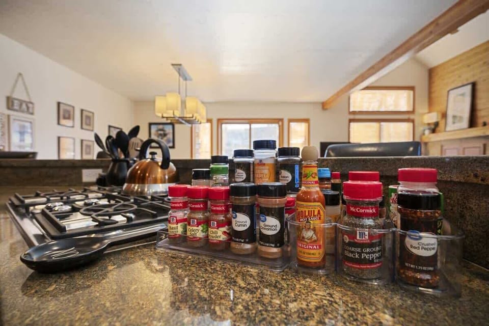 Kitchen stocked with a full spice rack and modern gas stove.