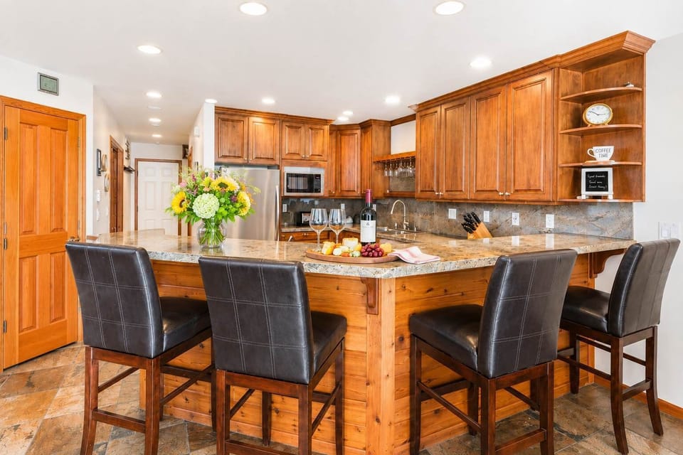 Spacious kitchen with wood cabinetry, bar seating, and modern appliances.