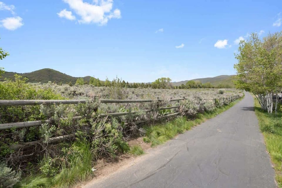 Scenic walking and biking trail surrounded by trees and mountain views—perfect for outdoor adventures.