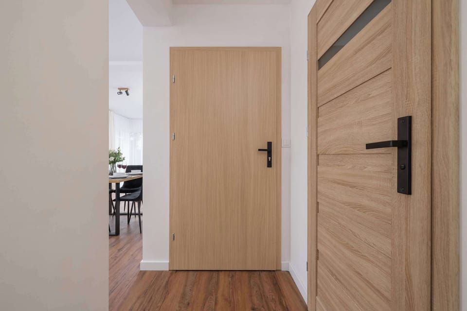 A bright and modern hallway with wooden flooring and minimalist decor. The space offers a welcoming first impression, combining simplicity with elegance.
