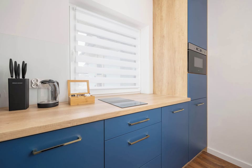 A corner of the kitchen with a black coffee machine and knife set. The design is practical yet elegant, perfect for daily use.