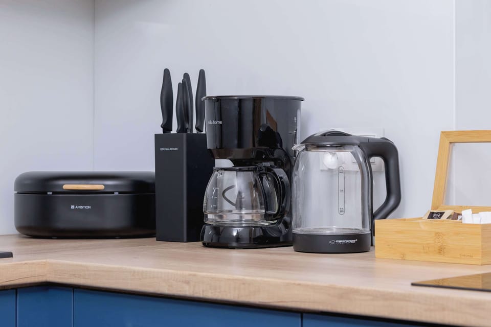 A kitchen counter with a toaster, electric kettle, and coffee maker. Everything needed for a comfortable morning routine.