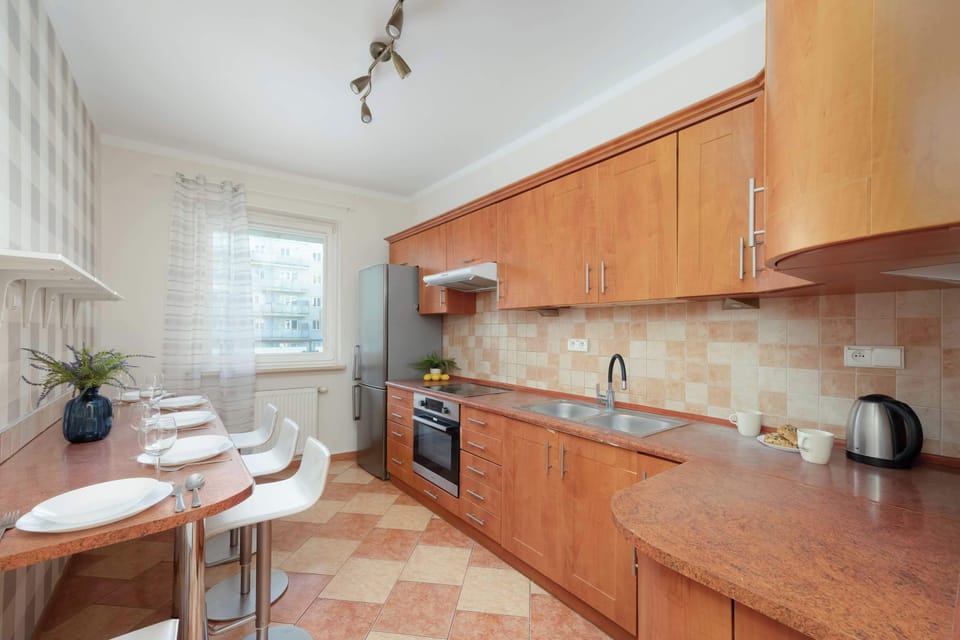 A kitchen view showing a dining setup with wooden cabinets and plenty of light. It looks modern and efficient for daily use.